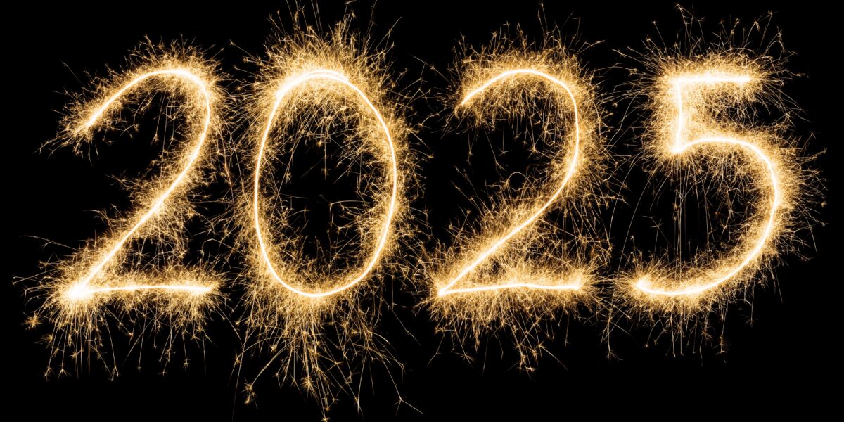 The numbers "2025" written with golden sparklers against a black background, creating a festive and bright effect.